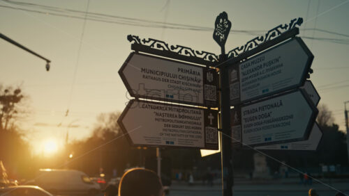 Video - Chisinau, Moldova - February 18, 2025: Beautiful twilight sets over the city as street signs guide visitors to important landmarks. The warm light enhances the city's charm and historical beauty.