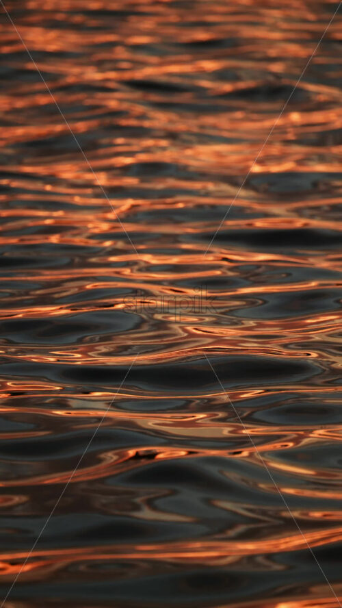 Video - Rippling water glimmers with golden hues from the setting sun. Abstract showcase of nature