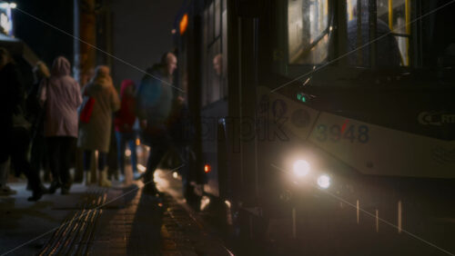 Video - Chisinau, Moldova - October 7, 2025: Raindrops fall as commuters gather at a trolleybus station during a wet night