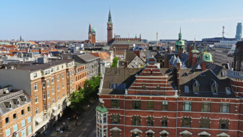 Video - Copenhagen, Denmark - August 6, 2025: Aerial drone view of the city's skyline with the iconic City Hall towers and historic architecture, surrounded by bustling streets