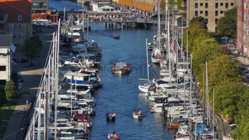 Video - Copenhagen, Denmark - August 6, 2025: Aerial drone view of Christianshavn Canal in Copenhagen, Denmark, lined with sailboats and yachts
