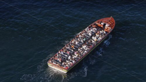 Video - Copenhagen, Denmark - August 6, 2025: Aerial drone view of a tourist canal boat cruising near the harborfront
