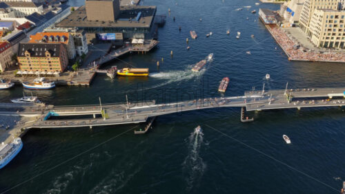 Video - Copenhagen, Denmark - August 6, 2025: Aerial drone view of the Royal Danish Playhouse on Copenhagen's waterfront, with people walking and cycling across Inderhavnsbroen bridge