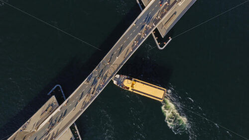 Video - Aerial drone view of a yellow harbor bus passing under the Lille Langebro, cycling and pedestrian bridge in Copenhagen, Denmark