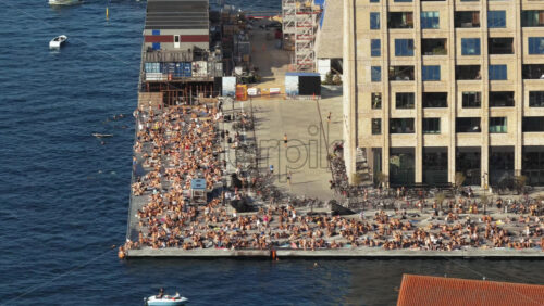 Video - Aerial drone view of the busy Islands Brygge waterfront filled with swimmers, sunbathers, and cyclists