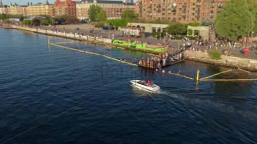 Video - Copenhagen, Denmark - August 6, 2025: Aerial drone view of the Royal Danish Playhouse on Copenhagen's waterfront, with people walking and cycling across Inderhavnsbroen bridge