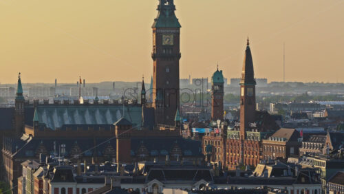Video - Copenhagen, Denmark - August 6, 2025: Aerial drone view of evening city traffic flowing along a wide street lined with historic brick buildings in Norre Voldgade