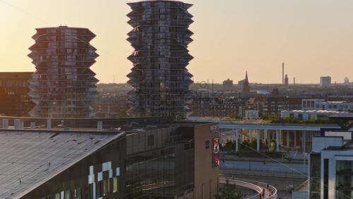 Video - Copenhagen, Denmark - August 6, 2025: Aerial drone view of the Cactus Towers with futuristic balconies, captured at sunset above the cityscape