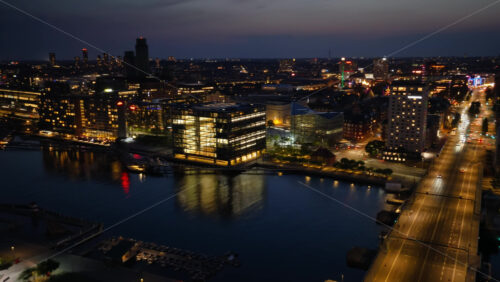 Video - Copenhagen, Denmark - August 6, 2025: Aerial drone view of Amager and Christianshavn at night, with glowing streets, Our Saviour's Church tower, and the harbor in the distance