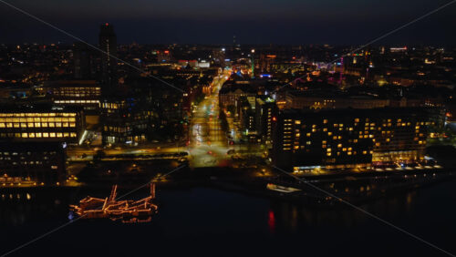 Video - Aerial drone view of Islands Brygge and Copenhagen's inner harbor with colourful reflections on the water and the Tivoli Gardens at night in Denmark