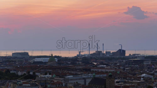 Video - Aerial drone view of the skyline of Copenhagen, Denmark with Amager Bakke and offshore wind turbines at sunrise
