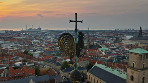 Video - Aerial drone view of rooster weather vane with panoramic view of Copenhagen rooftops, Denmark