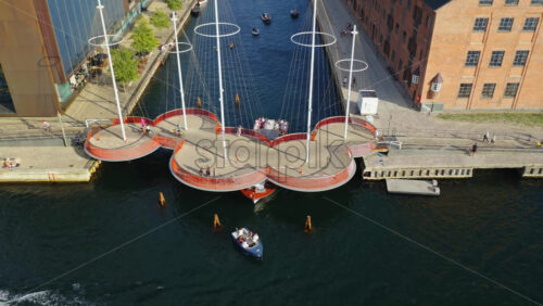 Video - Copenhagen, Denmark - August 7, 2025: Aerial drone view of the Circle Bridge with people crossing and boats below