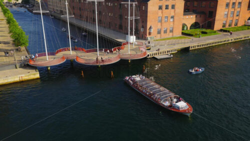 Video - Copenhagen, Denmark - August 7, 2025: Aerial drone view of the Circle Bridge across Copenhagen's Christianshavn canal with cyclists and boats
