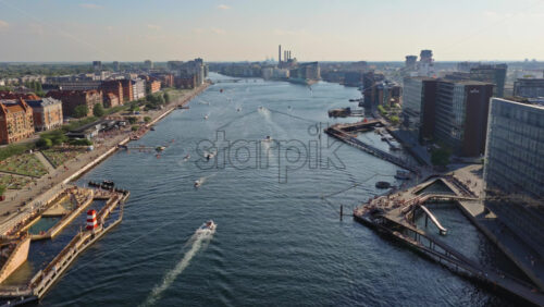 Video - Copenhagen, Denmark - August 7, 2025: Aerial drone view of Copenhagen harbor bath with people swimming, boats cruising, and modern waterfront buildings in the summer sun