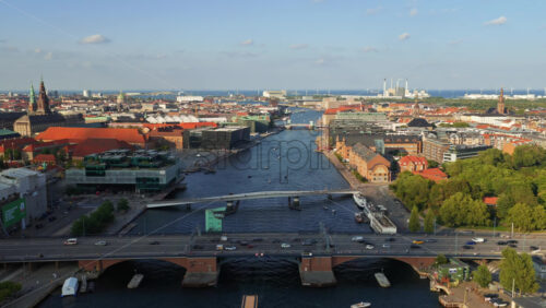 Video - Copenhagen, Denmark - August 7, 2025: Aerial drone view of the Copenhagen Inner Harbor showing boats, bridges, and people enjoying the waterfront on a sunny day