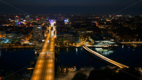 Video - Copenhagen, Denmark - August 7, 2025: Aerial drone time lapse of Copenhagen city lights with car traffic, bridges, and illuminated streets across the city at night