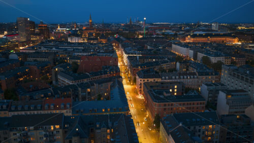Video - Copenhagen, Denmark - August 8, 2025: Aerial drone time lapse of city lights with car traffic, bridges, and illuminated streets across the city in the evening