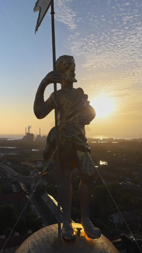 Video - Aerial drone view of the golden statue atop a sphere on the Church of Our Saviour overlooking the Copenhagen skyline, with Frederik's Church dome in the background in Denmark. Vertical
