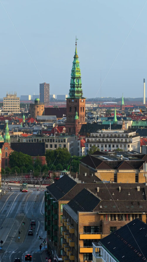 Video - Aerial drone view of central Copenhagen with spire of St. Nicholas Church at sunrise, Denmark. Vertical