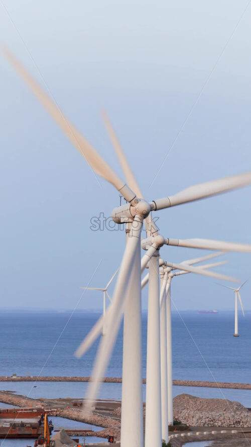 Video - Aerial drone view of offshore wind turbines spinning in the sea at the Oresund Wind Farm in Copenhagen, Denmark. Vertical