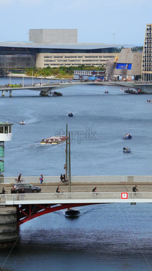 Video - Copenhagen, Denmark - August 4, 2025: Aerial drone view of the iconic green copper tower of Knippelsbro bridge with boats and canal activity in the heart of the city. Vertical