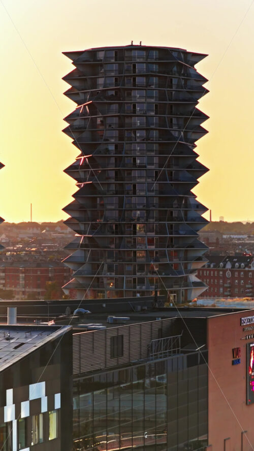 Video - Copenhagen, Denmark - August 6, 2025: Aerial drone view of red cycle bridge curving above the harbour, filled with cyclists commuting through the city. Vertical