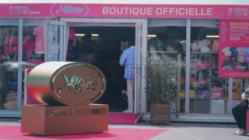 Video - Cannes, France - May 13, 2025: The Cannes Film Festival golden sign on a red carpet in front of a store