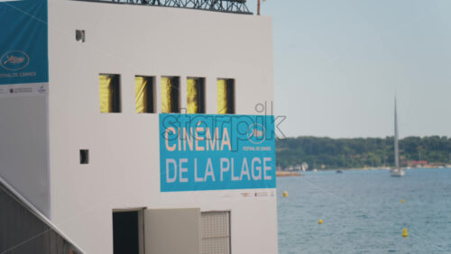 Video - Cannes, France - May 13, 2025: Beach cinema at the Cannes Film Festival with people relaxing on the beach in the background