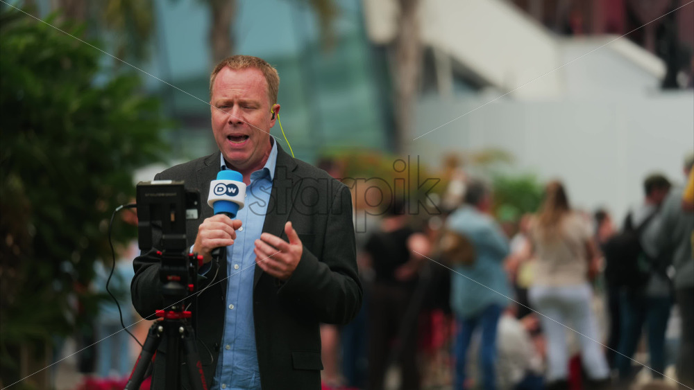 Video - Cannes, France - May 13, 2025: Man talking on the microphone in front of a camera at the Cannes Film Festival