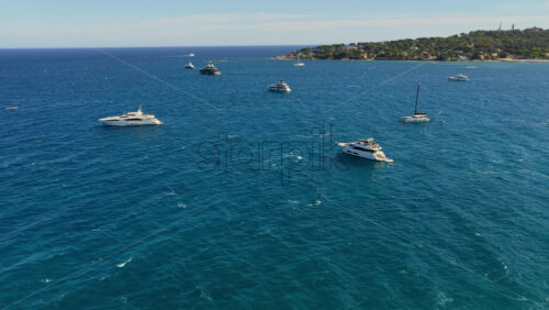 Video - Aerial drone view of luxury yachts and sailboats anchored in the blue waters of the Mediterranean Sea off the coast of Antibes