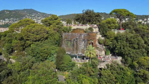 Video - Aerial drone view of the famous waterfall at Castle Hill in Nice, surrounded by lush trees and scenic viewpoints