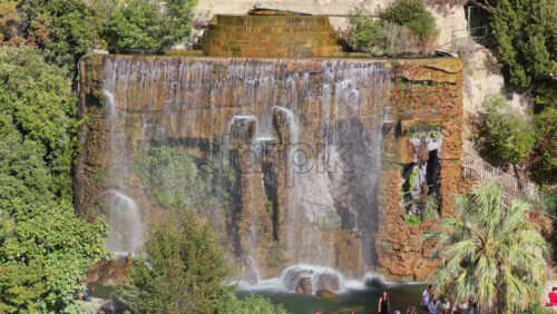 Video - Aerial drone view of the famous waterfall at Castle Hill in Nice, surrounded by lush trees and scenic viewpoints, Nice, France