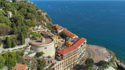 Video - Aerial drone view of Castle Hill in Nice with its fortress walls, curved road, and panoramic view over the Mediterranean coastline