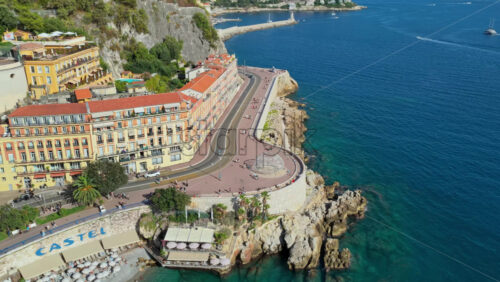 Video - Nice, France - September 5, 2025: Aerial drone view of Castel Plage beach and the curved coastal road at the foot of Castle Hill, Nice.