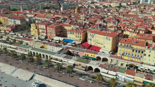 Video - Aerial drone view of Nice Old Town with colorful buildings, terracotta rooftops, and busy beachfront