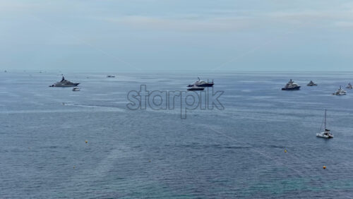 Video - Aerial drone view of luxury superyachts anchored in the calm waters off Cannes on the French Riviera in black and white
