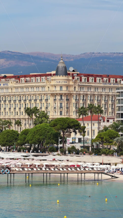 Video - Cannes, France - September 6, 2025: Aerial drone view of the Carlton Hotel on La Croisette, Cannes, with beach clubs and Mediterranean seaside. Vertical