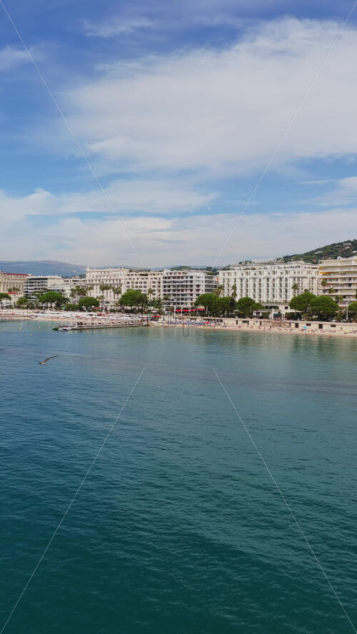 Video - Aerial drone view of the sandy beach with turquoise water and curved shoreline. Vertical, Cannes, France