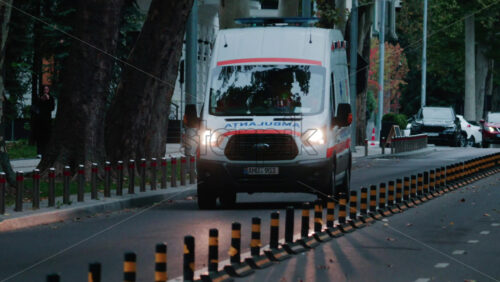 Video - Chisinau, Moldova - October 1, 2025: Emergency ambulance driving through a city street with flashing blue lights during dusk