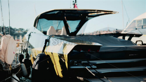 Video - Cannes, France - October 13, 2025: Modern gold luxury yacht docked in a sunny harbor, surrounded by sailboats