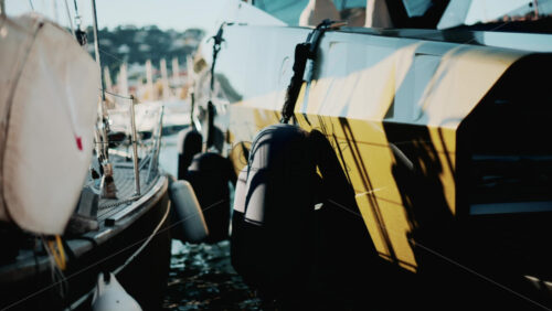 Video - Cannes, France - October 13, 2025: Modern gold luxury yacht docked in a sunny harbor, surrounded by sailboats