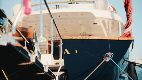 Video - Rear angle of a luxury blue yacht with wooden details docked in a marina