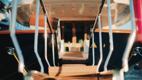 Video - Low angle close up of a yacht gangway leading onboard, with polished chrome handrails and soft golden light