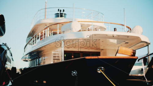 Video - Low angle view of a luxury yacht docked in a marina under blue sky