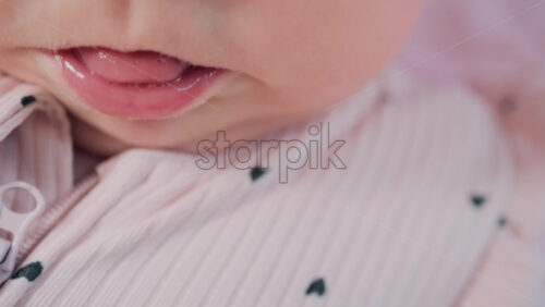 Video - Close up of baby's lips and cheeks in warm pastel light