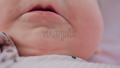 Video - Close up of baby's lips and cheeks in warm pastel light