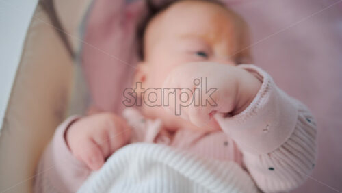 Video - Close up of baby's tiny hand reaching out gently in soft pastel tones