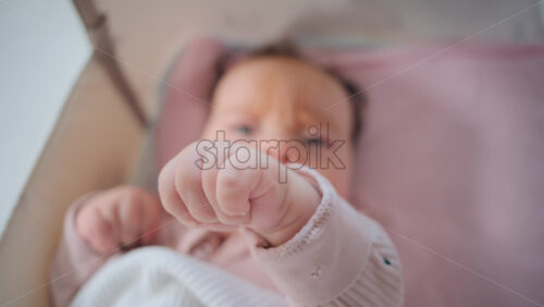 Video - Close up of baby's tiny hand reaching out gently in soft pastel tones