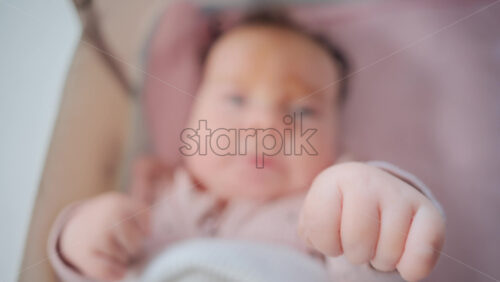 Video - Close up of baby's tiny hand reaching out gently in soft pastel tones